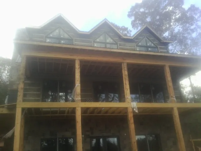 Dormers and porch framing on a large log home under construction — Roof Coating work by our crew in Folcroft