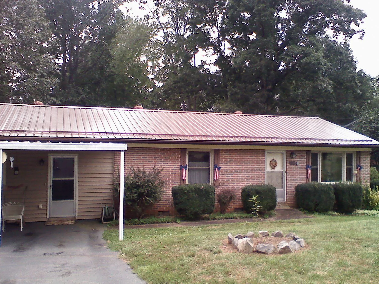 Bronze metal roof and carport on a brick ranch home — Roof Repair work by our crew in Folcroft